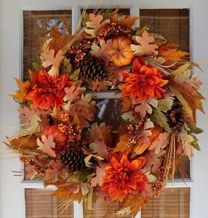 fall door wreath with pinecones and flowers