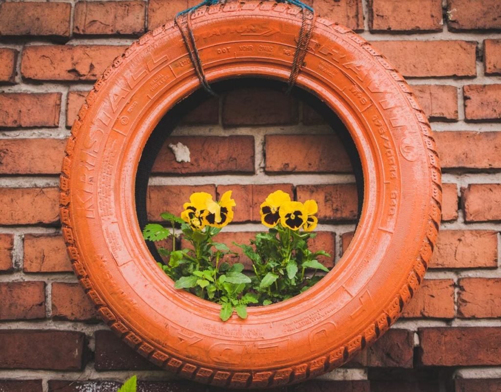 tire planter painted red on red brick wall