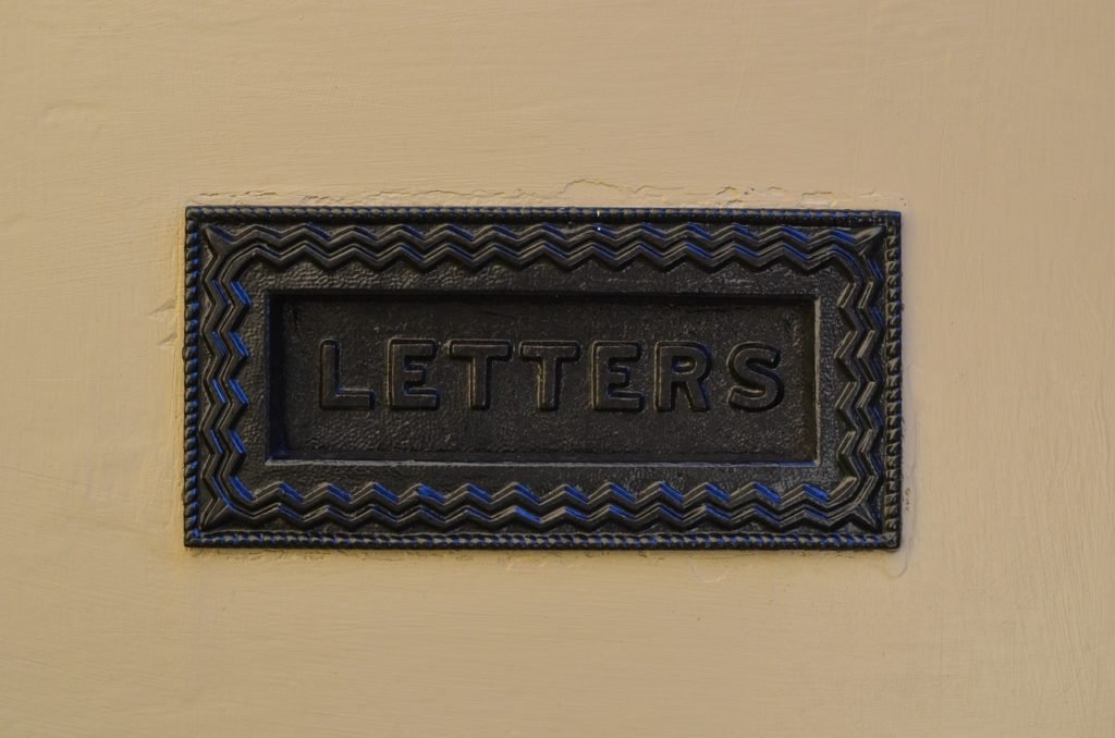 classic-looking mailslot in a dark metal with the word "letters" on the flap.
